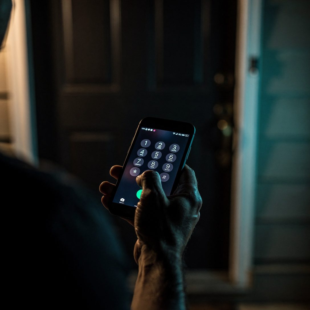 Personne composant le numero d'un serrurier sur son telephone